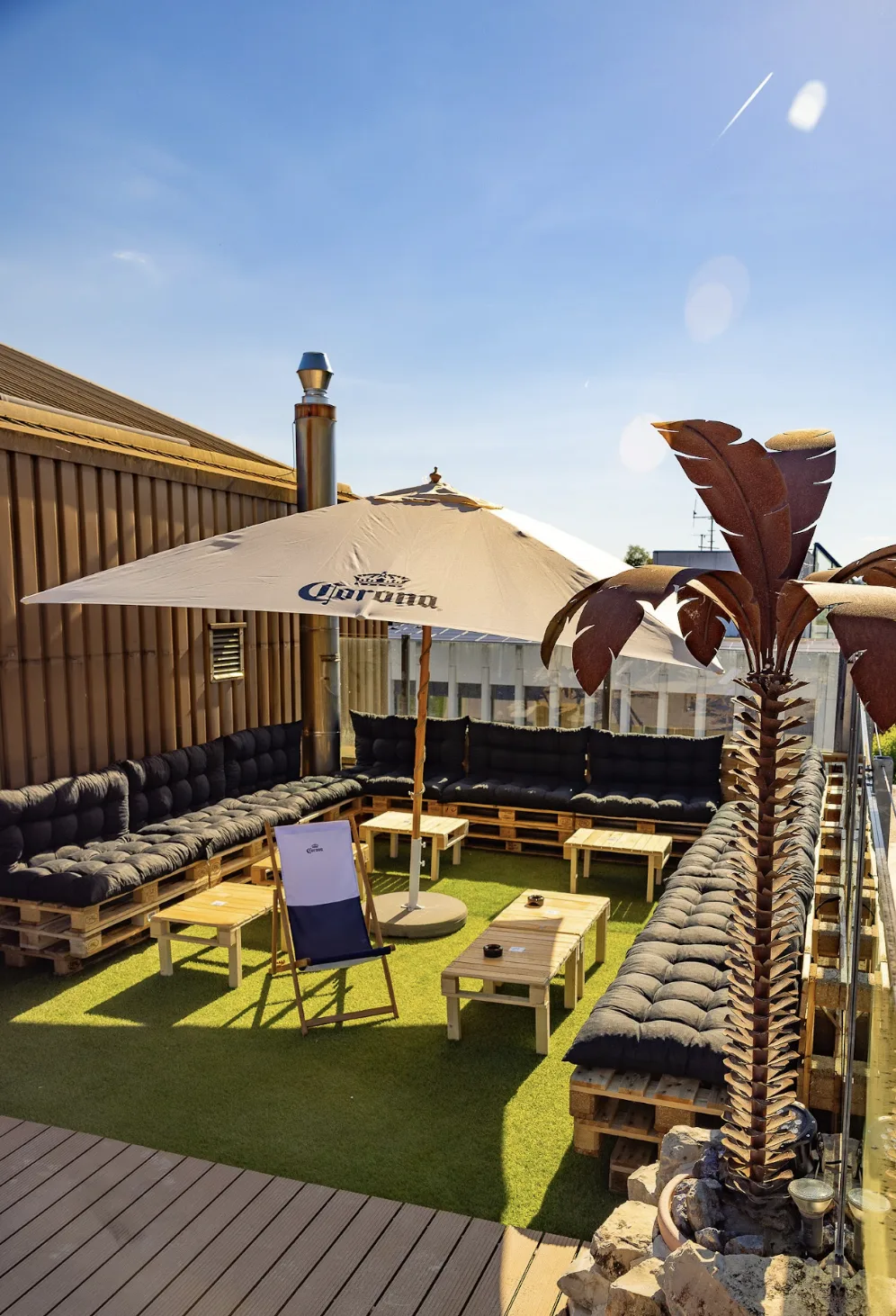Rooftop Aarau Lounge mit Palmen und Aussicht bei Sonnenuntergang