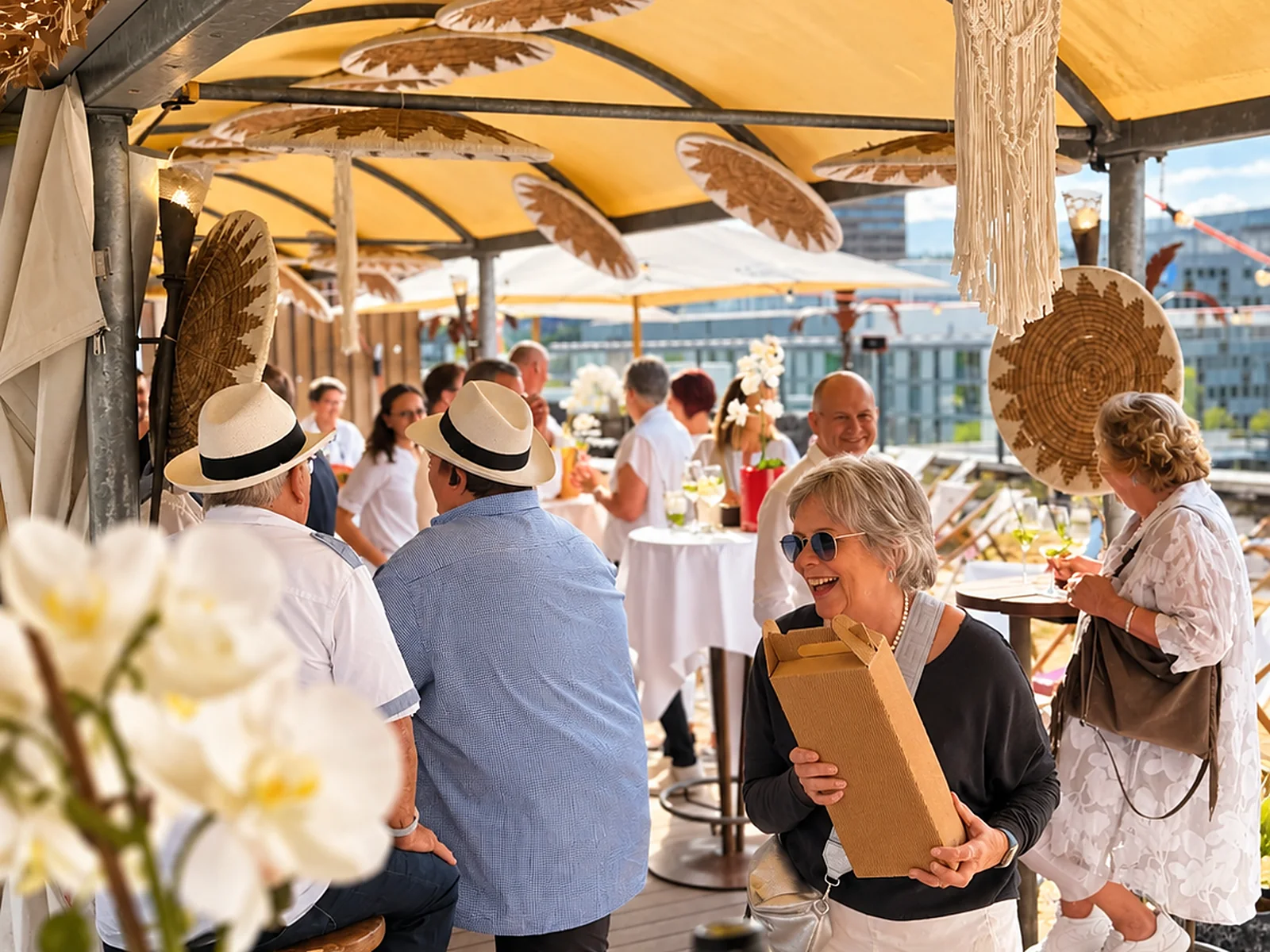 Gäste beim Apéro unter dem gelben Pavillon mit Strohdeko auf der Rooftop Aarau Terrasse