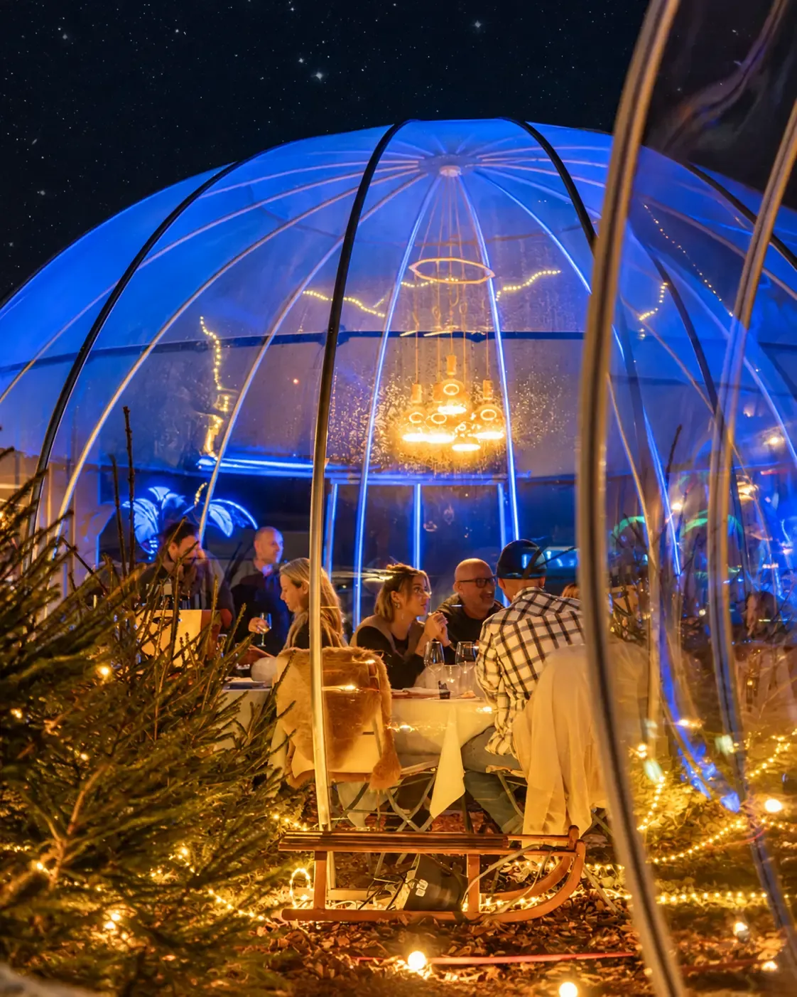 Gäste beim gemeinsamen Winterabend im blau beleuchteten Iglu auf dem Rooftop Aarau
