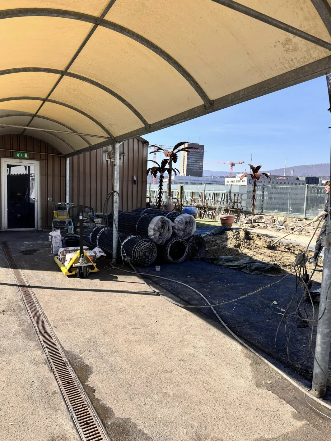 Materialrollen unter dem gelben Vordach während des Umbaus