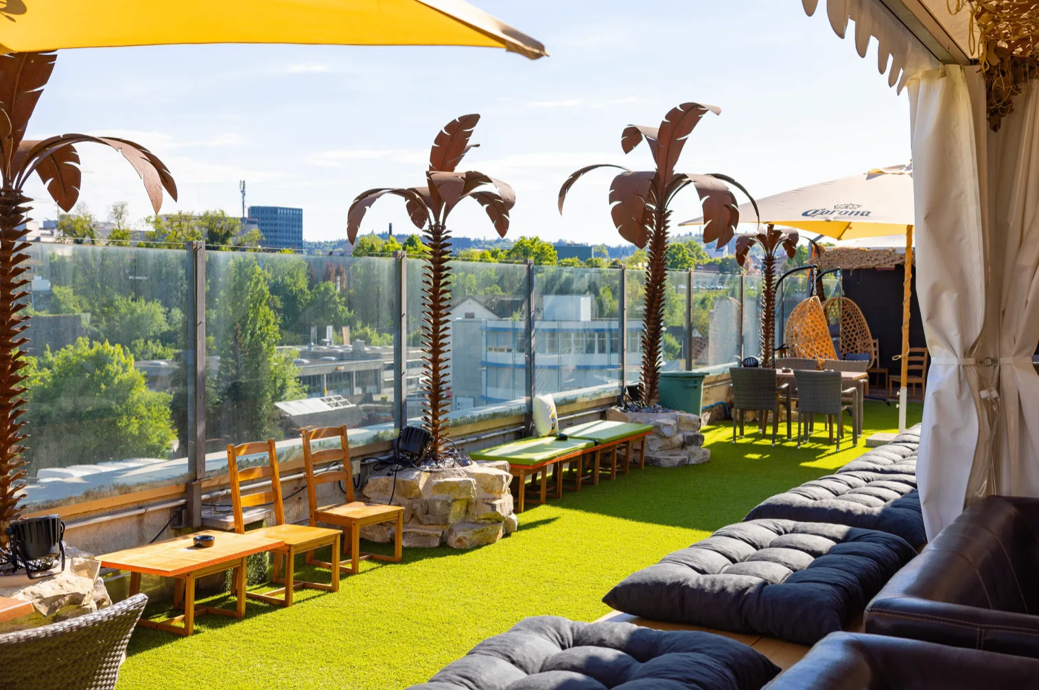 Fertige Lounge-Ecke mit Palmen, Sofa und Kunstrasen
